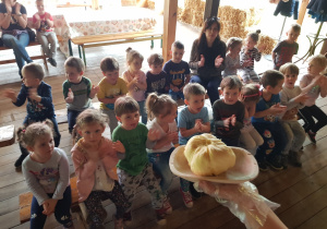 Ubite masło na tle dzieci z grupy "Żabki".