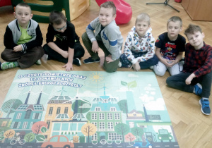 Chłopcy z grupy Pandy z dumą prezentują puzzle, które ułożyli jako pierwsi. Na puzzlach widnieje hasło - O czyste powietrze dbaj i z odnawialnych źródeł energii korzystaj.