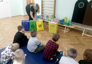 Pani pokazała dzieciom kosze - trzy torby na śmieci, które również nadają się do segregacji odpadów takich jak papier, szkło i plastik.