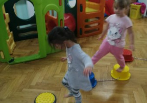 Dziewczynki z grupy "Żyrafek" przechodzą po stopniach sensorycznych.