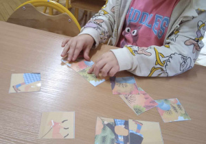 Dziewczynka układa puzzle przy stoliku