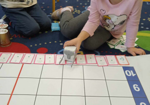 Dziewczynka programuje robota Genibota za pomocą kart