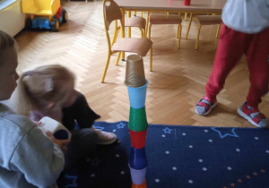 Dzieci układają kolorową wieże z kubeczków