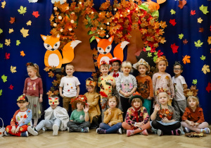 Przedszkolaki z drugiej grupy "Żyrafek", pozują do zdjęcia na tle dekoracji na Balu Jesieni w dniu 24.10.2023r.