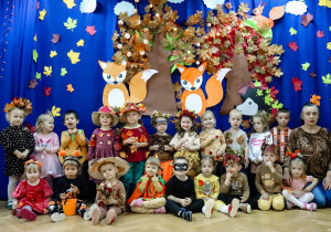 Dzieci z grupy najmłodszej na tle dekoracji z Panią Małgosią.