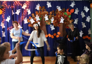 Nauczycielki wraz z Panią Dyrektor ilustrują taniec z paskami bibuły.