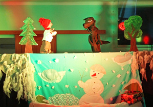 Zimowa dekoracja oraz lalki chłopca i wilka wykorzystane w przedstawieniu.