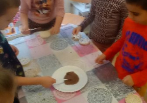 Dzieci smarują wafle ryżowe zdrowym kremem czekoladowym