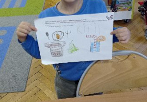 Chłopiec pokazuje pierwsze śniadanie, które narysował