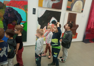 Część dzieci ze starszaków stoi przy obrazach.