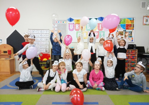 Dzieci podrzucają balony na sygnał nauczycielki.