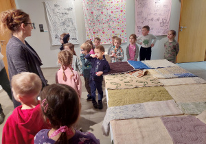 Dzieci oglądają prace w dziale z tkaninami.