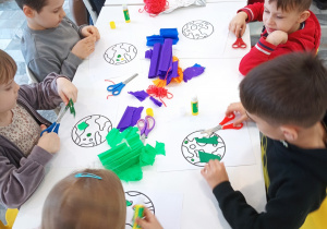 Dzieci ozdabiają planety z papieru.