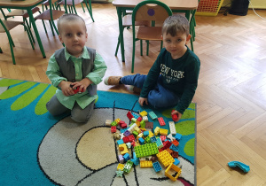 Dwóch chłopców buduje z klocków lego dupplo.