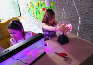 Dziewczynki przy stoliku z podświetlanymi lampami.