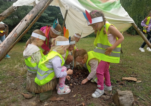 Dziewczynki z drugiej grupy zajęte układaniem szyszek w tipi.
