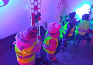 Dzieci z trzeciej grupy wkładają małe piłeczki w stojaki o różnych kształtach.