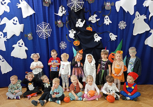 Dzieci z grupy "Żabki" pozują do pamiątkowego zdjęcia na tle dekoracji przed balem w dniu 31.10.2025r.