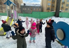 Dzieci z grupy Żabek bawią się na placu zabaw na terenie przedszkola.