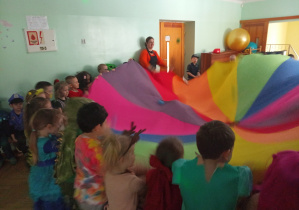 Dzieci wachlują chustę.