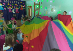 Dzieci chowają się pod chustą.