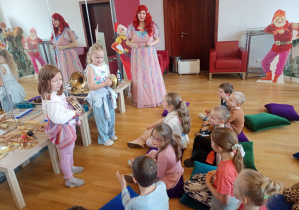 Dziewczynki grają na wybranych instrumentach: tamburynie i talerzach.