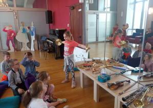 Dziewczynka gra na talerzach.