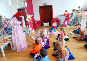 Przewodniczka wita się z dziećmi a dziewczynki są zachwycone jej suknią.