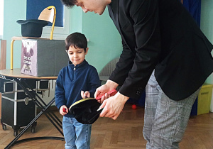 Chłopiec czaruje magiczną różdźką, by naprawić worek.