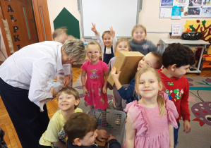 Pani Dyrektor wypakowuje kosz z zabawkami.