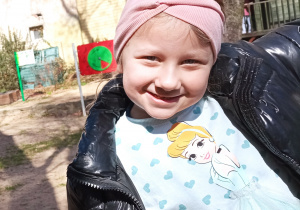 Uśmiechnięta dziewczynka na placu zabaw.
