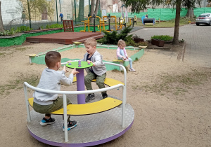 Dwóch chłopców kręci się na karuzeli.