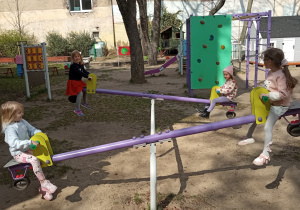 Dziewczynki bujają się na huśtawkach wagowych.