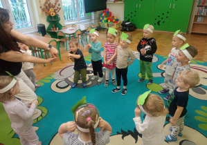 Pani Małgosia uczy dzieci nowej piosenki.