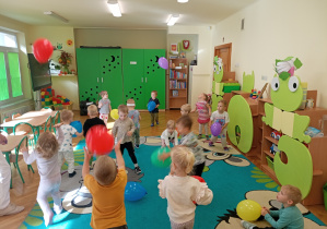 Maluszki podrzucają i łapią swoje baloniki.