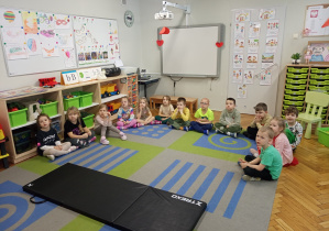 Dzieci z grupy trzeciej siedzą i uważnie słuchają, tego co mówi Pani Ratowniczka.