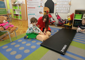 Chłopiec z grupy "Małpek" ćwiczy uciskanie klatki piersiowej.