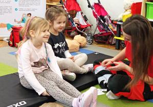 Dziewczynki czekają na naklejenie plasterków.