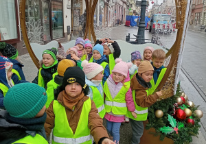 Dzieci przed instalacją bożonarodzeniową.