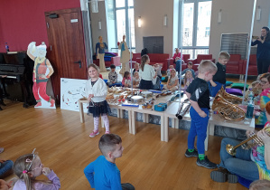 Dziewczynka gra na trójkącie a chłopiec zastanawia się jaki instrument wybrać..