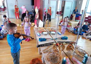 Troje dzieci daje koncert swojej publiczności.