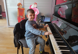 Chłopiec gra na pianinie.