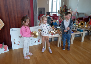 Troje dzieci daje koncert dla kolegów.