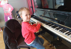 Chłopczyk gra na pianinie.