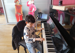 Chłopczyk z trzeciej grupy gra na pianinie.