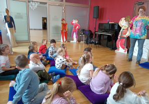 Pani pokazuje dzieciom jak grać na talerzach.