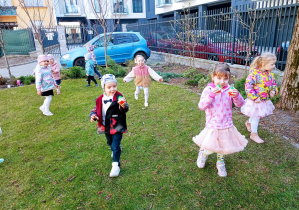 Radosne maluszki biegają i skaczą po trawie.
