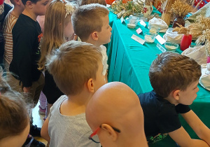 Dzieci przyglądają się darom zebranym z pól.