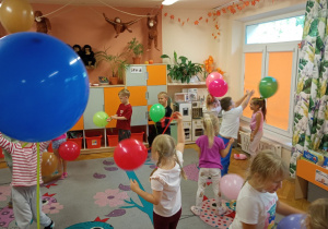 Dzieci z grupy trzeciej swobodnie bawią się balonami.