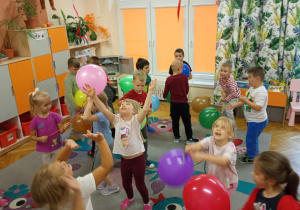 Dzieci cieszą się zabawą balonami.